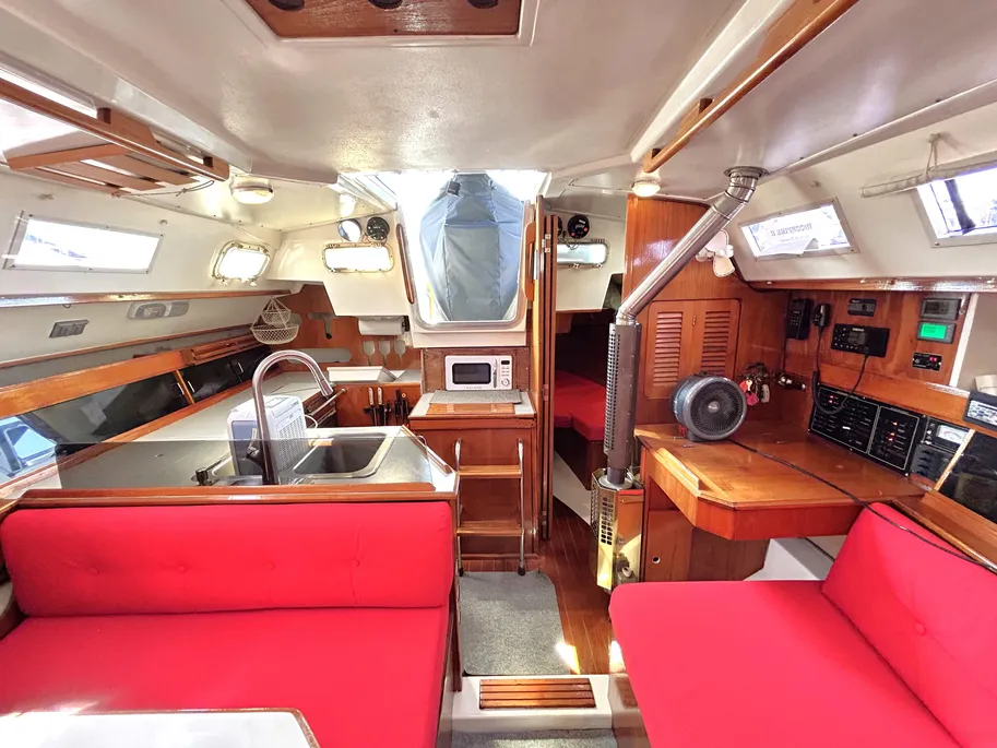 The main cabin features an unusual athwartships dinette arrangement instead of the more common U-shape. The galley originally came with a two-burner kerosene stove, though most owners have since converted to propane or CNG. Courtesy of YachtWorld