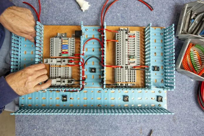 A marine electrician working on an electric panel in a workshop