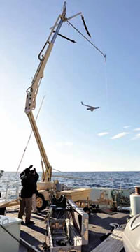 A device called a skyhook uses an elastic cable to snare the wing tip of ScanEagle for retrieval.