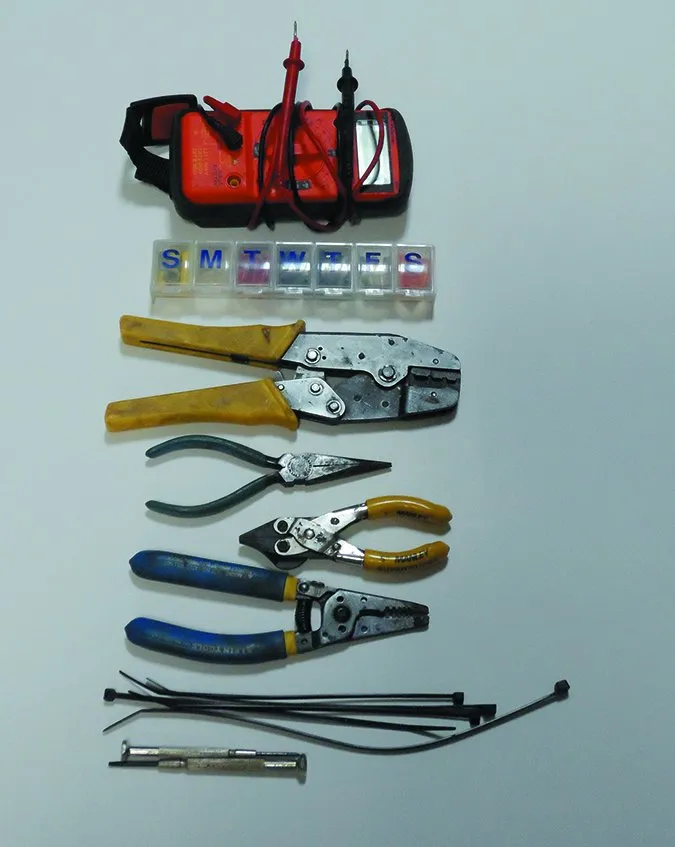 Most electrical repairs can be fixed with a few tools, from top: multimeter, box of butt connectors, ratchet crimper, needle nose pliers, side-cutting wire cutter, wire stripper, plastic ties, micro-screw drivers.
