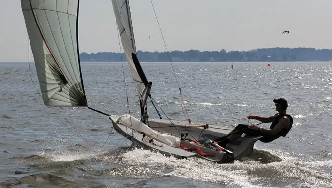 Lighter displacement hulls with flat sections and beam carried aft, like this high-performance dinghy, are designed to plane. Because there is less mass to accelerate and less wetted surface to create drag, they can achieve thrilling speeds off the wind.