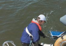 Testers were always tethered to the boat, even in light weather. In heavy weather, two hands are required to manhandle drogues and the deck is moving; the tether saved us from going over many times. A bucket lashed to the stern rain was handy for handling chain rode without scratching gelcoat.