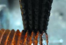Straightening 1-inch pipe threads using a General Tools thread restoring file. To use the file, align the file with threads, and work from good threads outwards, so that several of the rows of teeth are always engaged with good threads. Use moderate pressure; enough to keep the file from skipping, but not enough to cut deeply into the pipe or bolt. Take your time. Clean with wire brush when finished.
