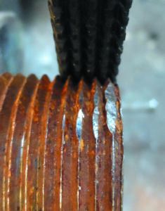 Straightening 1-inch pipe threads using a General Tools thread restoring file. To use the file, align the file with threads, and work from good threads outwards, sothat several of the rows of teeth are always engaged with good threads. Use moderate pressure; enough to keep the file from skipping, but not enough to cut deeply into the pipe or bolt. Take your time. Clean with wire brush when finished.