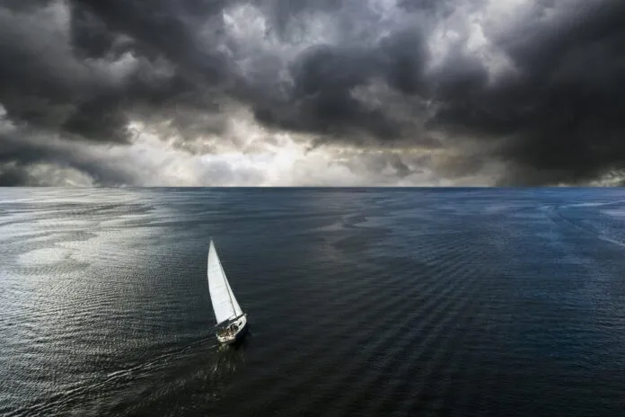 Aerial view of a yacht in a storm with a dramatic sky