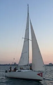 Sailors on this J-22 fly the jib at sunset. Jibs allow boats to point closer to the wind. (Photo/ Nick Van Antwerp)
