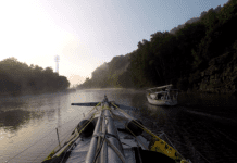 LadyK on the Erie Canal with a mast on deck to navigate under bridges.