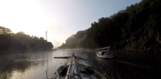 LadyK on the Erie Canal with a mast on deck to navigate under bridges.