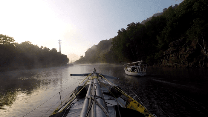 LadyK on the Erie Canal with a mast on deck to navigate under bridges.