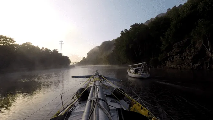 LadyK on the Erie Canal with a mast on deck to navigate under bridges.