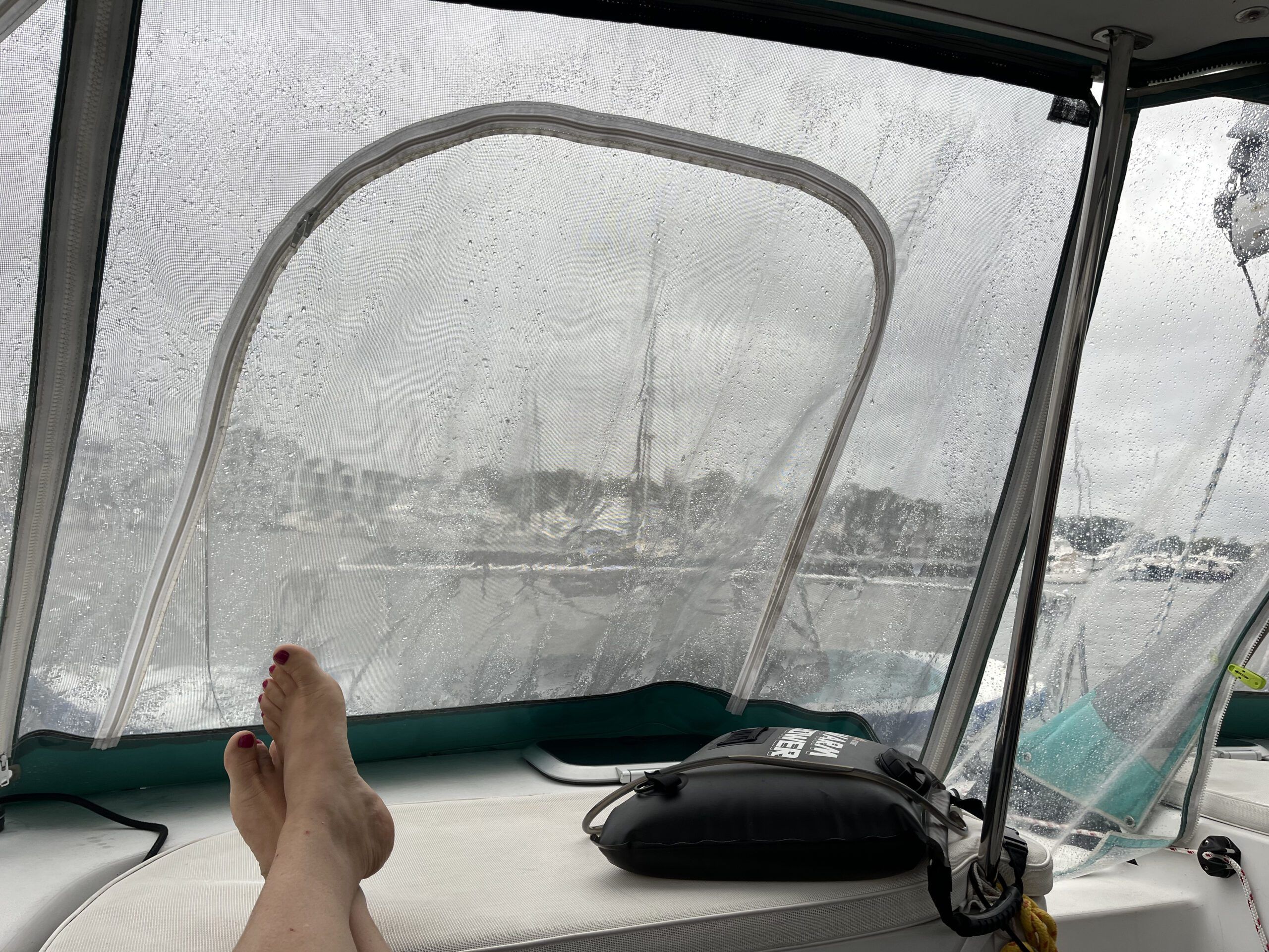 A full vinyl enclosure keeps the cockpit dry on a rainy day. This is the view looking aft from the helm during a rainy day. That solar shower won't be getting very warm today! (Photo/ Alex Jasper)
