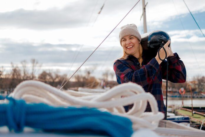 Sailor Woman Attaching a Fender to a Boat