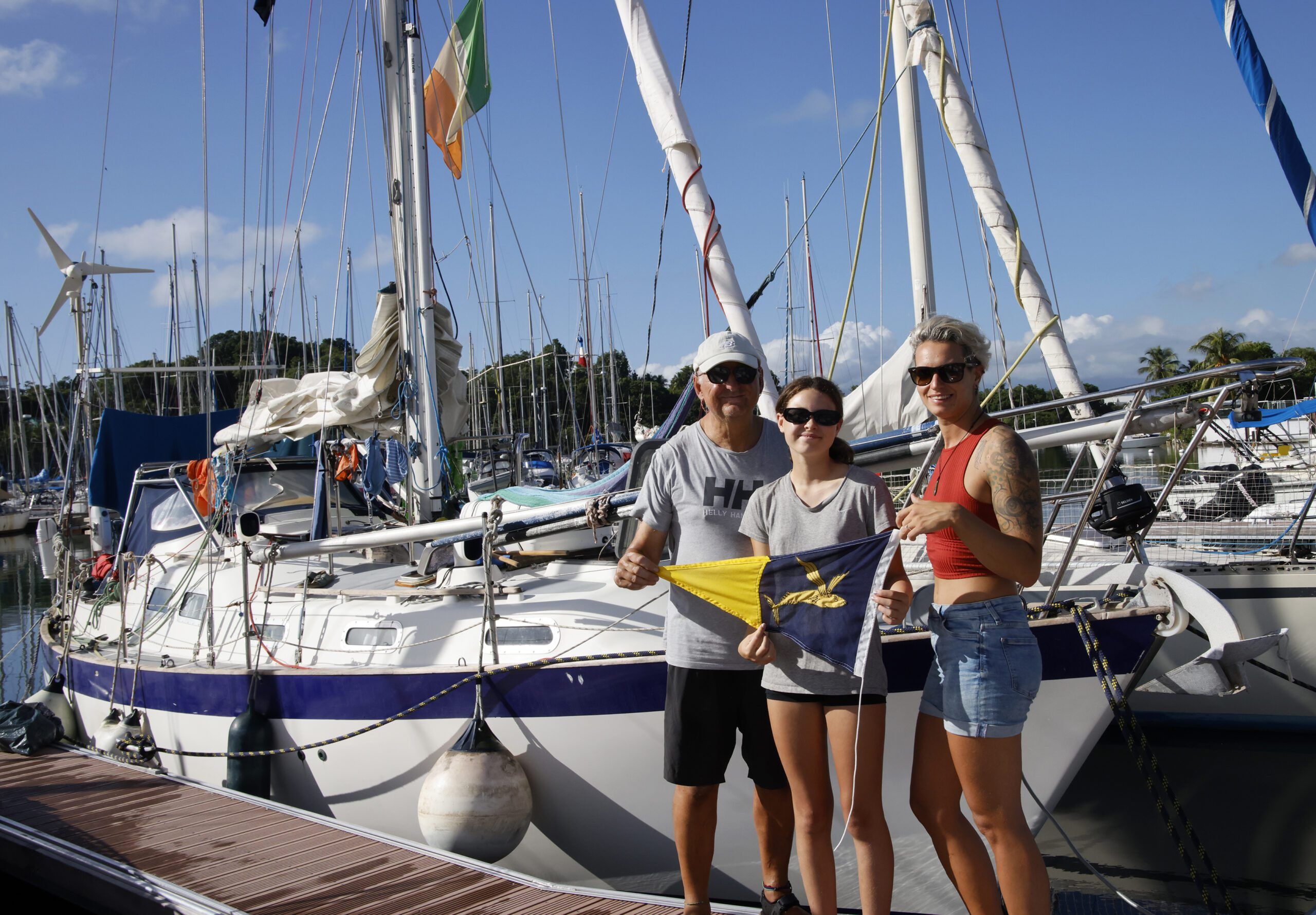 Mairin, captain and crew in Guadeloupe with the Ocean Cruising Club flag. (Photo/ Leszek Wolnik)