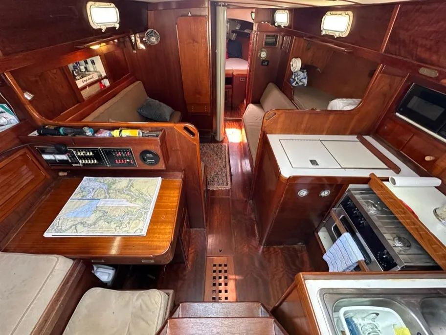 In early hulls, the main cabin offered a pilot berth to starboard, affording extra crew (or a child) a place to grab some sleep during a race or long passage. Later hulls used this space for storage. The dining table folds up against the main bulkhead. This is a 1978 Tartan 37. Photo courtesy of Yacht World.
