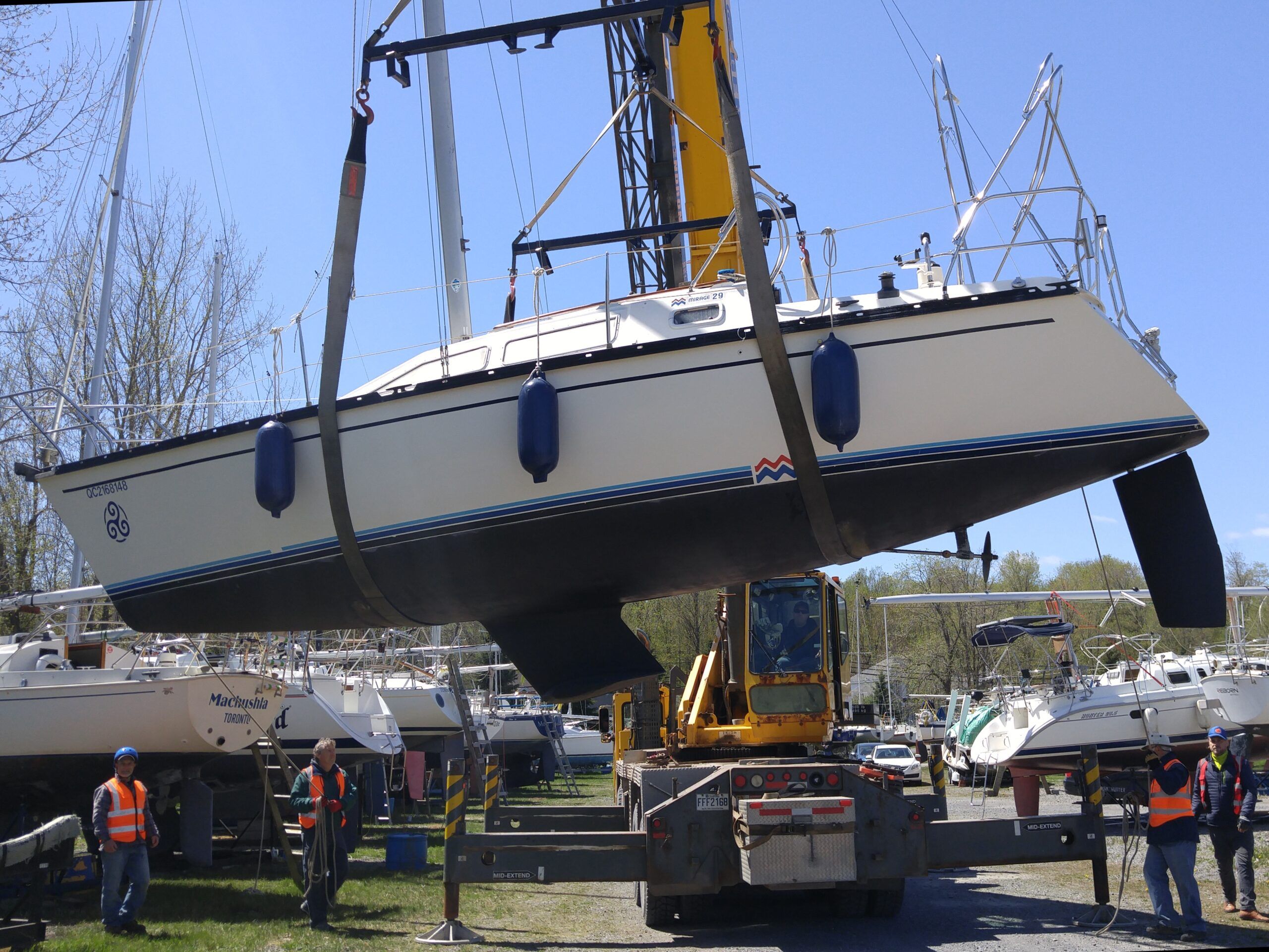 These slings are both located where the cradle pads will land. The crew will have to carefully add temporary blocks in order to reposition the slings and reset the boat on the cradle properly. Notice the boat is also imbalanced, bow down. (Photo/ Marc Robic)