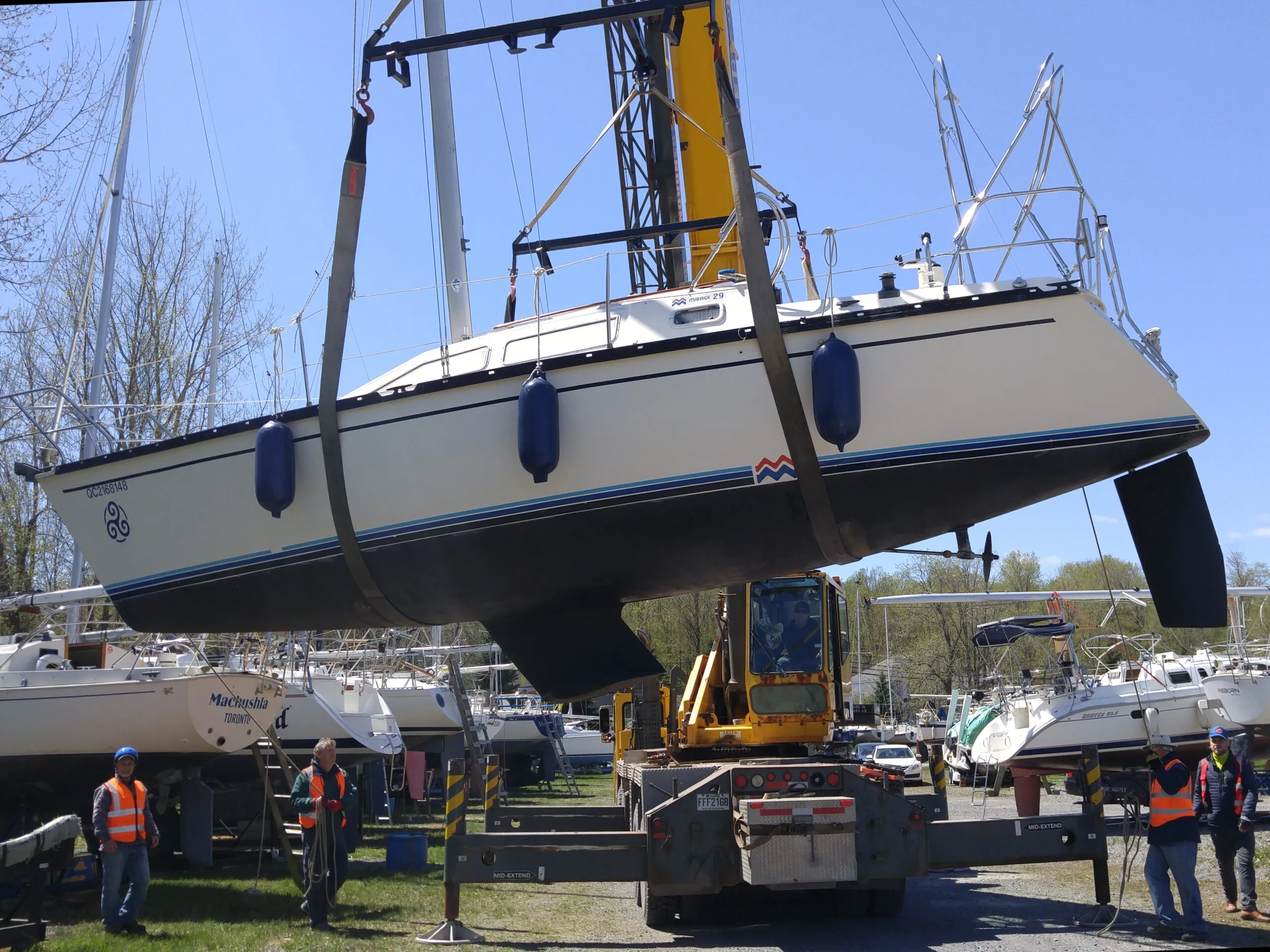 These slings are both located where the cradle pads will land. The crew will have to carefully add temporary blocks in order to reposition the slings and reset the boat on the cradle properly. Notice the boat is also imbalanced, bow down. (Photo/ Marc Robic)