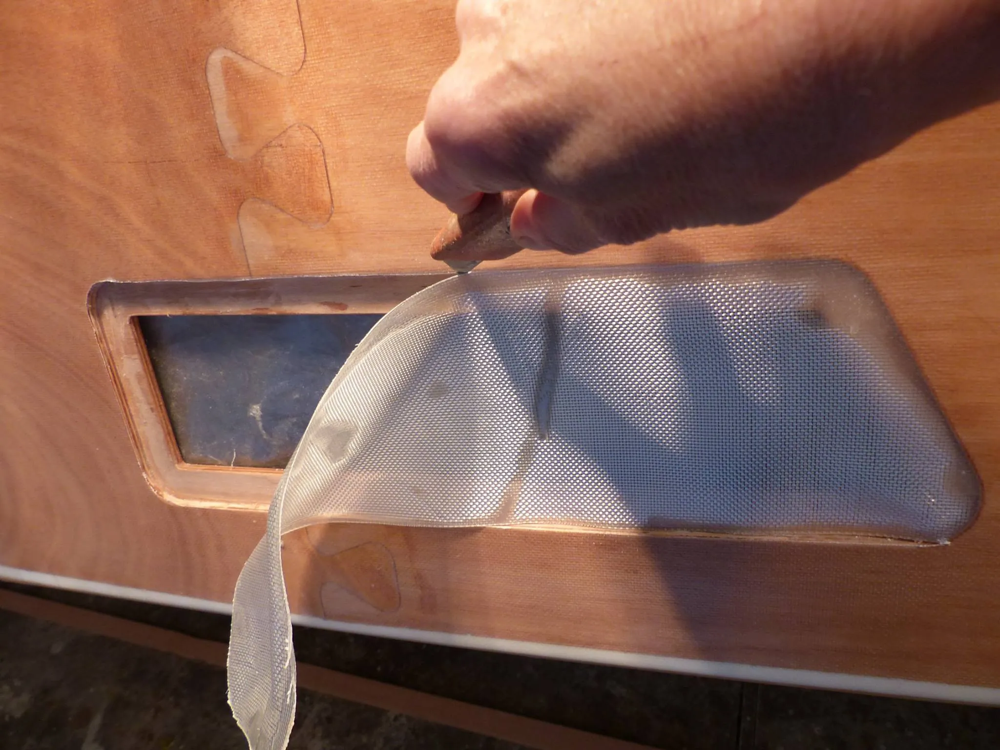 The glass edges are trimmed once the resin is set. (Photo courtesy of Wharram Designs)