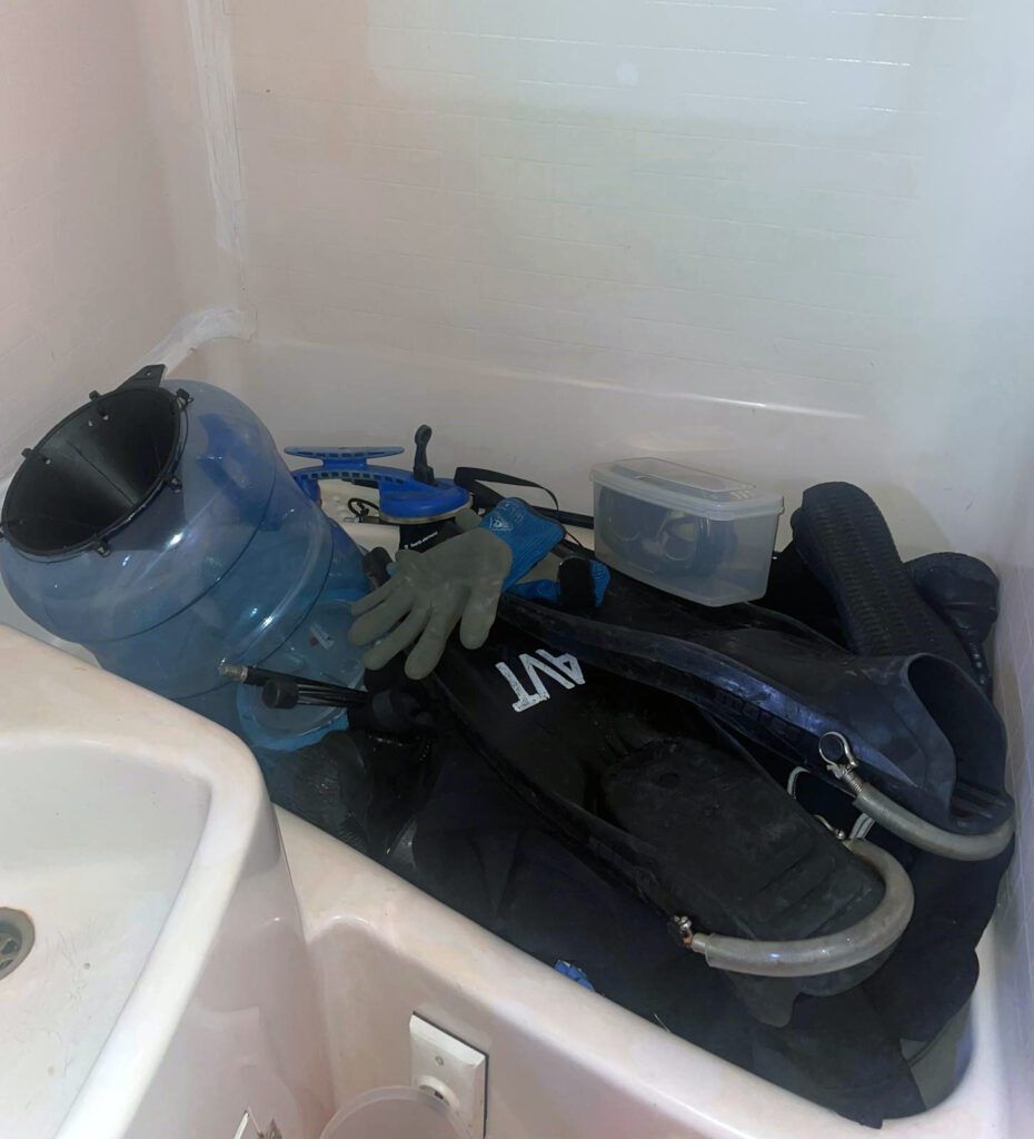 Dive equipment storage in an unused bathtub aboard Andrew Trent’s Reload and Charge, a Deen 400 catamaran. Note the mask is in a mask box and there is a lionfish tamer and hull cleaning suction handle with the equipment. (Photo/ Andrew Trent)