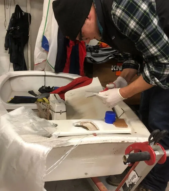 Even if you can’t sail in winter in some places, you can still work on other necessary boat skills. Here I am repairing the mast collar on an Optimist inside of the youth sailing classroom at Columbia Yacht Club in Chicago in January. In the winter, the lake freezes and there is no sailing on the Great Lakes, so I used my time to help repair club boats. I learned from my high school sailing coach, turned friend and mentor, how to do the fiberglass work and much more. He is not pictured but is just out of the frame teaching me this new skill. (Photo/ Nick Van Antwerp)