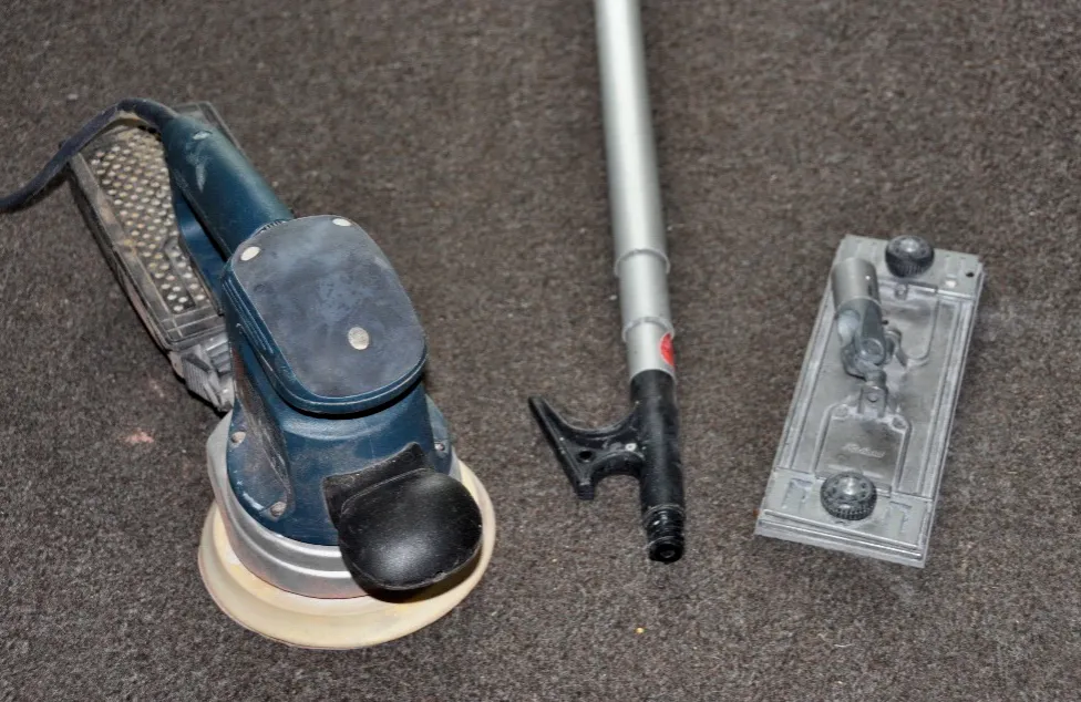 You'll need an orbital sander, a boat hook (or other adjustable pole, like a painter's pole), a heavy-duty metal pole sanding head, a foam block and zip ties. (Photo/ Bert Vermeer)