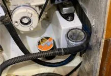 The dinghy pump connected to the raw water hose removed from the strainer, ready to blow air back through the saildrive leg, ready to be taped. (Photo/ Bert Vermeer)