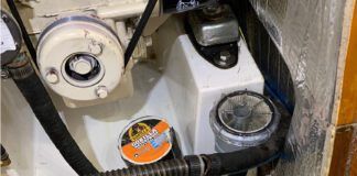 The dinghy pump connected to the raw water hose removed from the strainer, ready to blow air back through the saildrive leg, ready to be taped. (Photo/ Bert Vermeer)