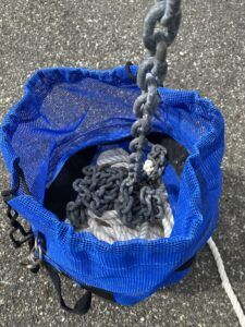 Rode bags are made of mesh to promote drying. This West Marine bag includes shape-retaining stainless hoops, a metal clip for attaching the bag to a stanchion or bow rail, webbing carry straps, and a reinforced slit at the bottom of the bag for passing the bitter end through to securing the rode to a bow cleat. (Photo/ Doug Henschen) 