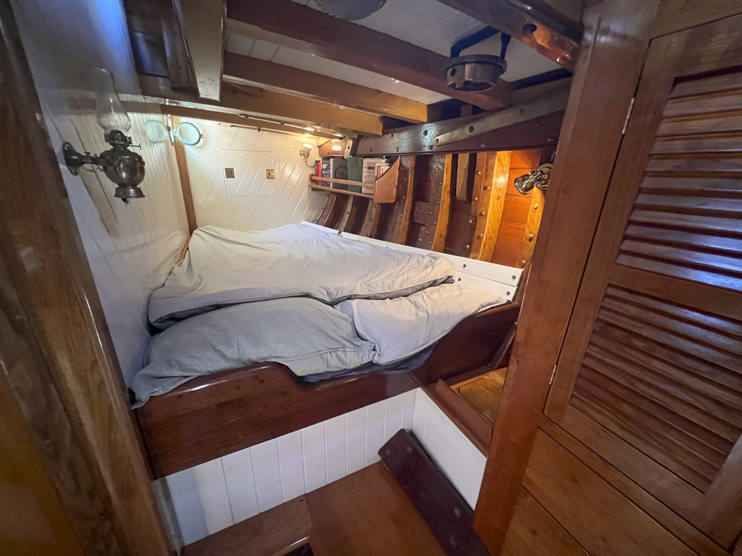 The captain's cabin featuring a wide double berth, traditional and LED lighting. Note the visible ribs, deck beams and overhead compass. (Photo/ Leo Sampson Goolden)