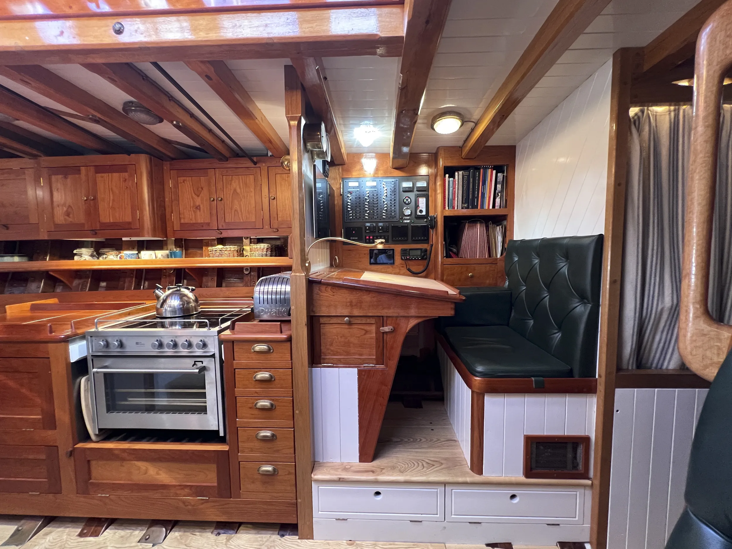 Tally Ho's traditional forward facing navigation station with room for guide and maintenance books, the deck light illuminating the electrical panel. (Photo/ Leo Sampson Goolden)