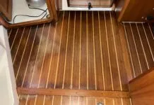 The cabin sole with water damage, looking aft towards the companionway from the salon. The new damage is on the left, while the old damage is near the doorway at the top of the photo. (Photo/ Bert Vermeer)