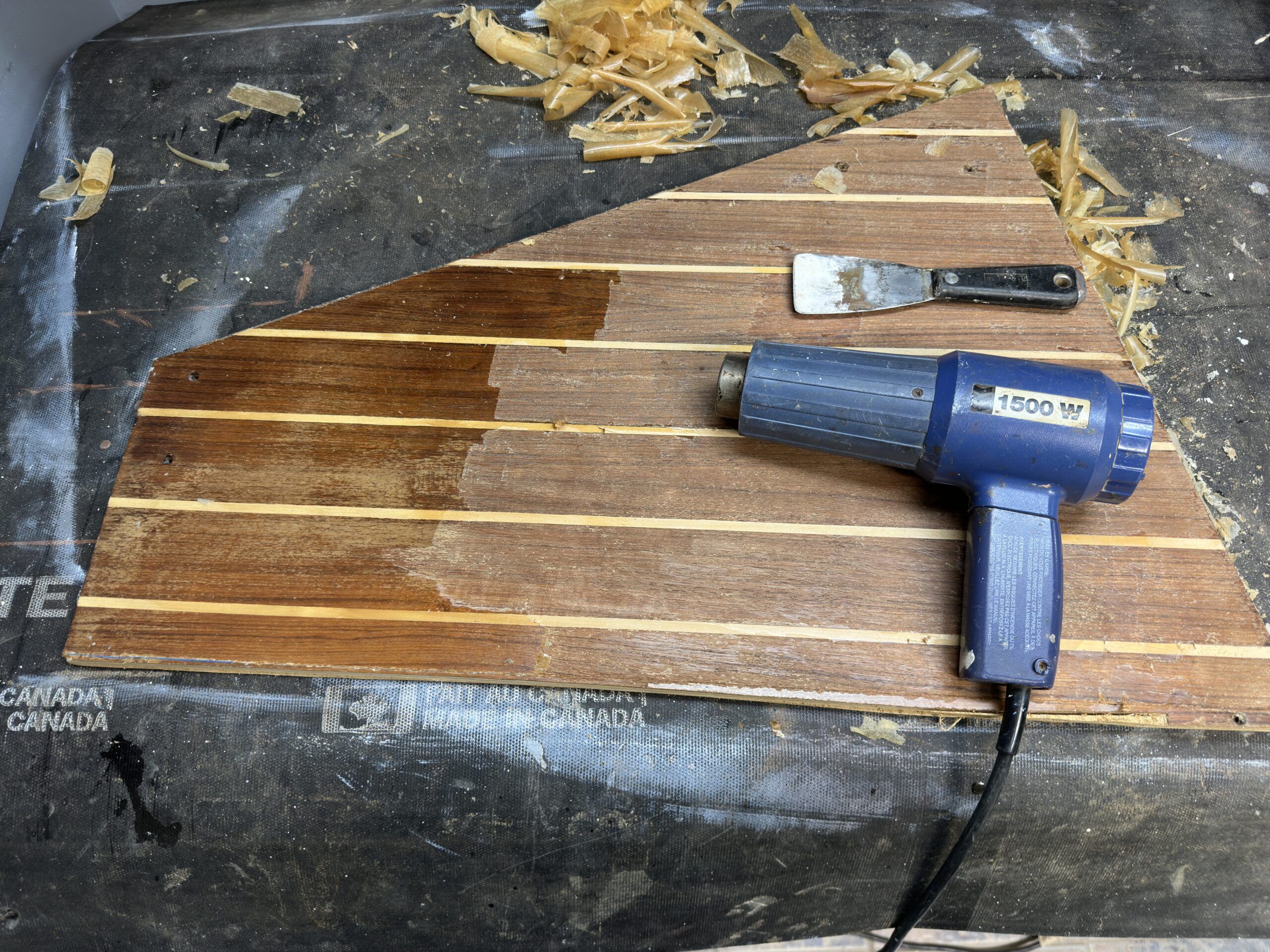 The stripping of the top layer of varnish starts with a putty knife and heat gun. Care must be taken not to gouge through the finish nor to burn the underlying wood. (Photo/ Bert Vermeer)