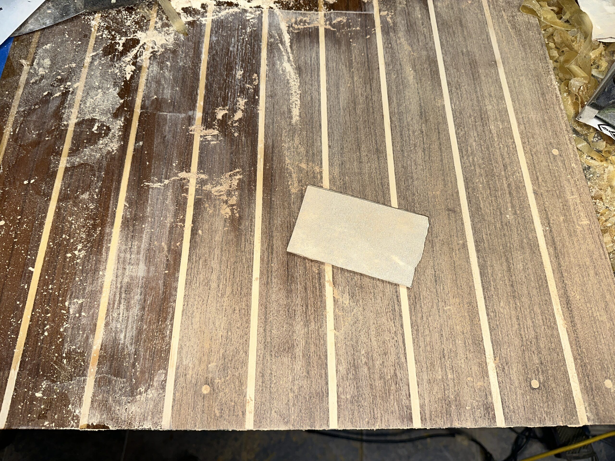 Once the top layer of varnish is removed, then the laborious task of hand sanding the very thin veneer of teak and holly is undertaken. (Photo/ Bert Vermeer)