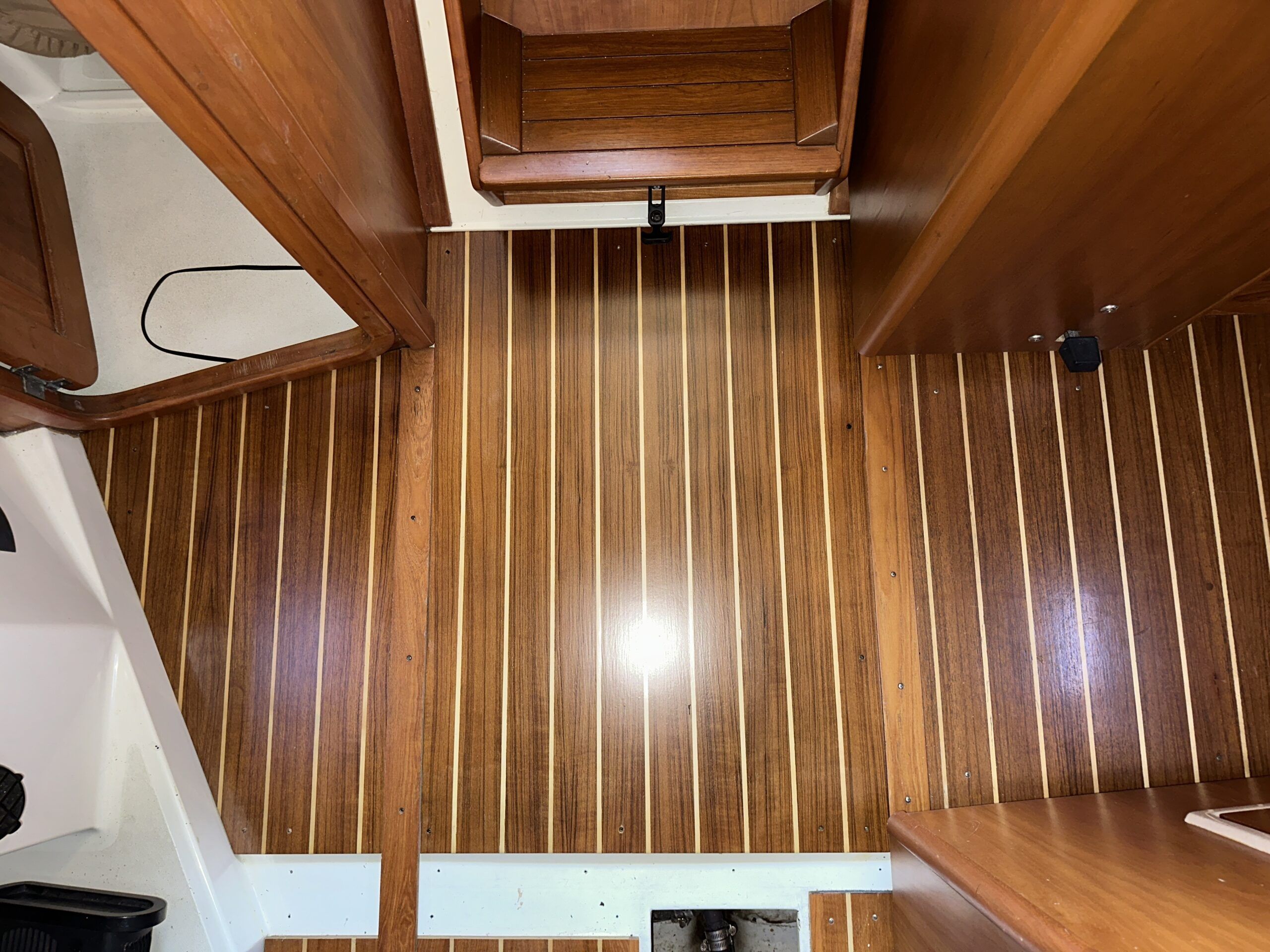 The former athwartship teak transition piece now must be trimmed to become the new longitudinal transition piece. (Photo/ Bert Vermeer)