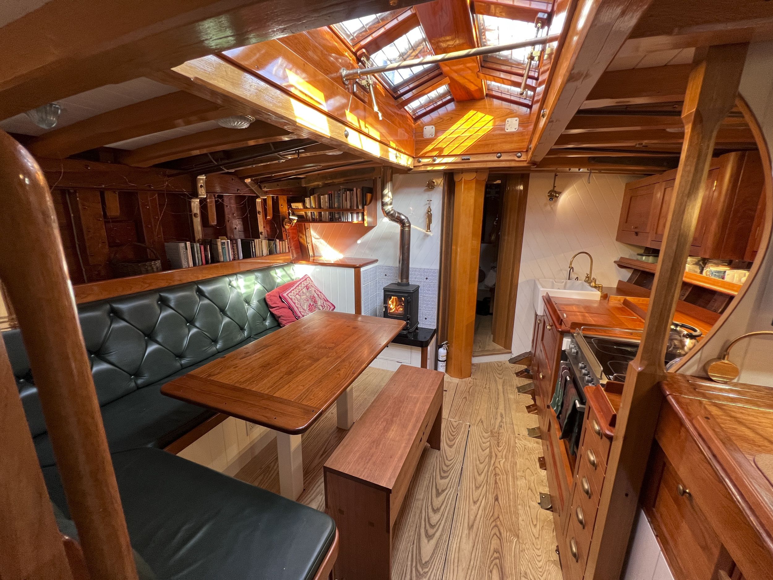 The starboard galley, salon table in the foreground illuminated by the massive butterfly skylight. (Photo/ Leo Sampson Goolden)