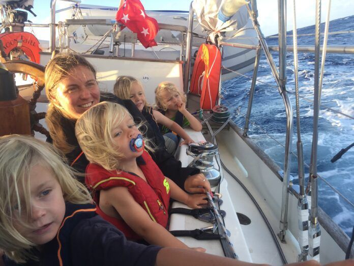Carolyn Powles with her brood aboard a 1978 Herreshof Mobjack ketch, at sunrise on passage to Fiji. (Photo/ Carolyn Powles)