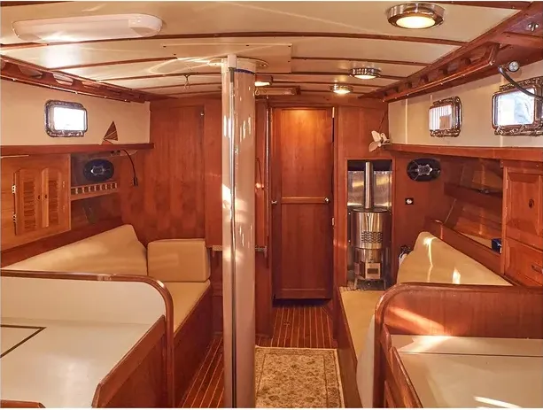 The ample main saloon features a fold-down table and two full-length settees for sea berths during long passages. Offset slightly to port, the companionway’s position allows for a bigger galley and a wider aft cabin. 