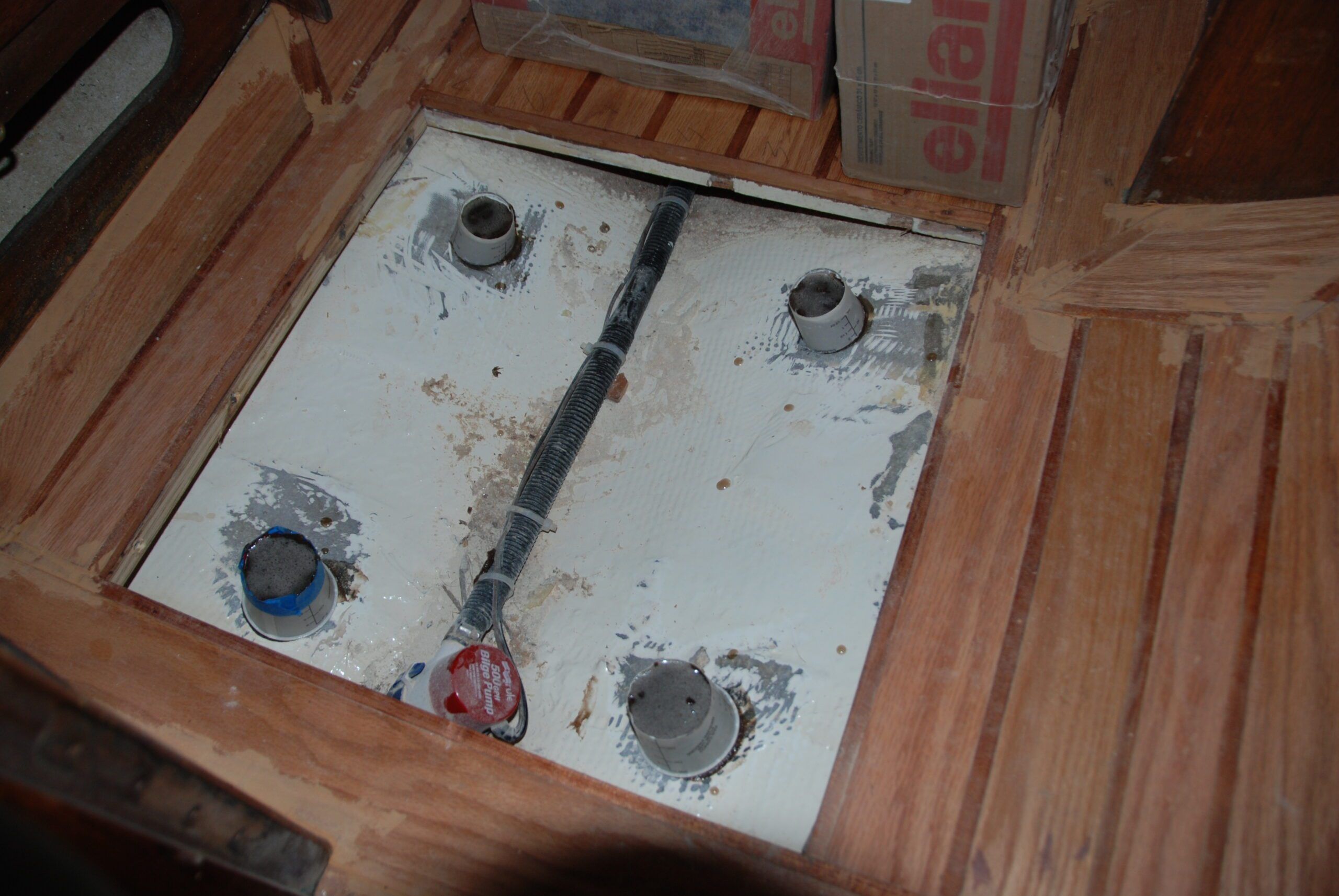 All the planking is installed, two of the weight boxes still holding down freshly epoxied planks. The shower grate supports epoxied onto the shower sump. (Photo/ Bert Vermeer)