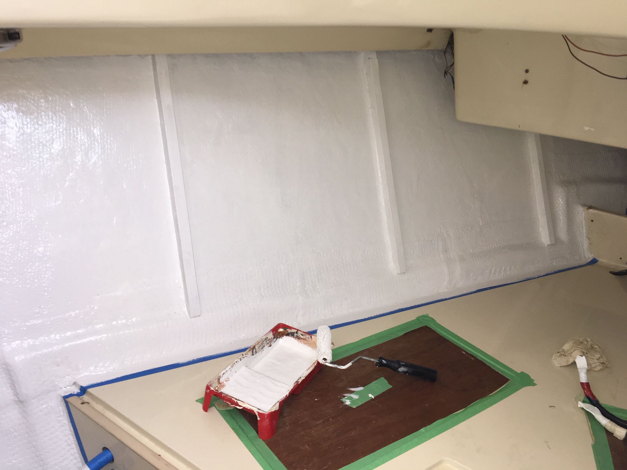 Painting the raw fiberglass and ribs before installing the ½” closed cell insulation foam. (Photo/ Bert Vermeer)