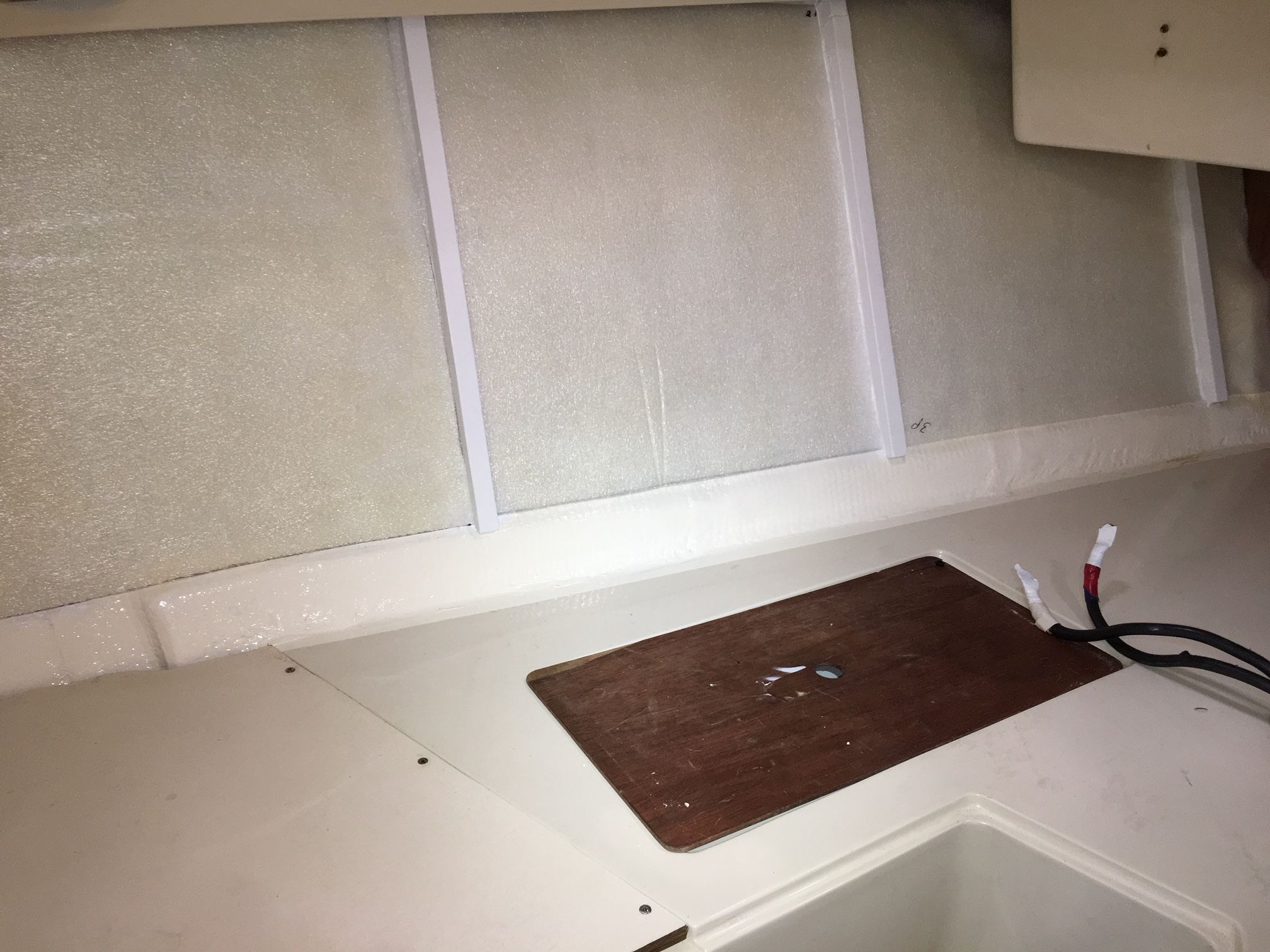 The closed cell ½” foam glued into place with contact cement. Note that the bottom edge, not to be covered with the oak strips, has been finished in the same color as the original gelcoat and wood. (Photo/ Bert Vermeer)