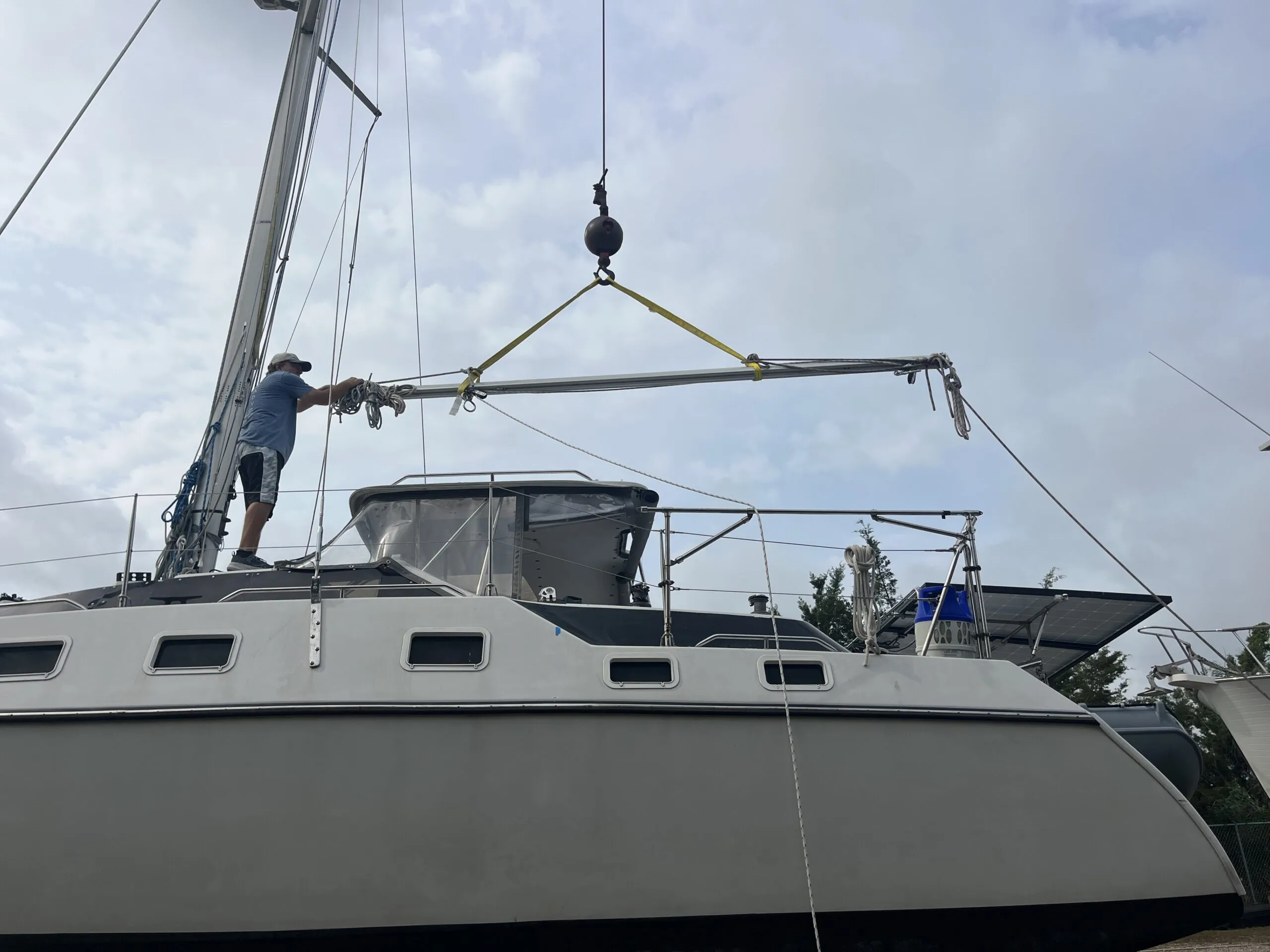 After restepping the mast, months later, a crane relifts the boom back aboard. (Photo/ Alex Jasper)