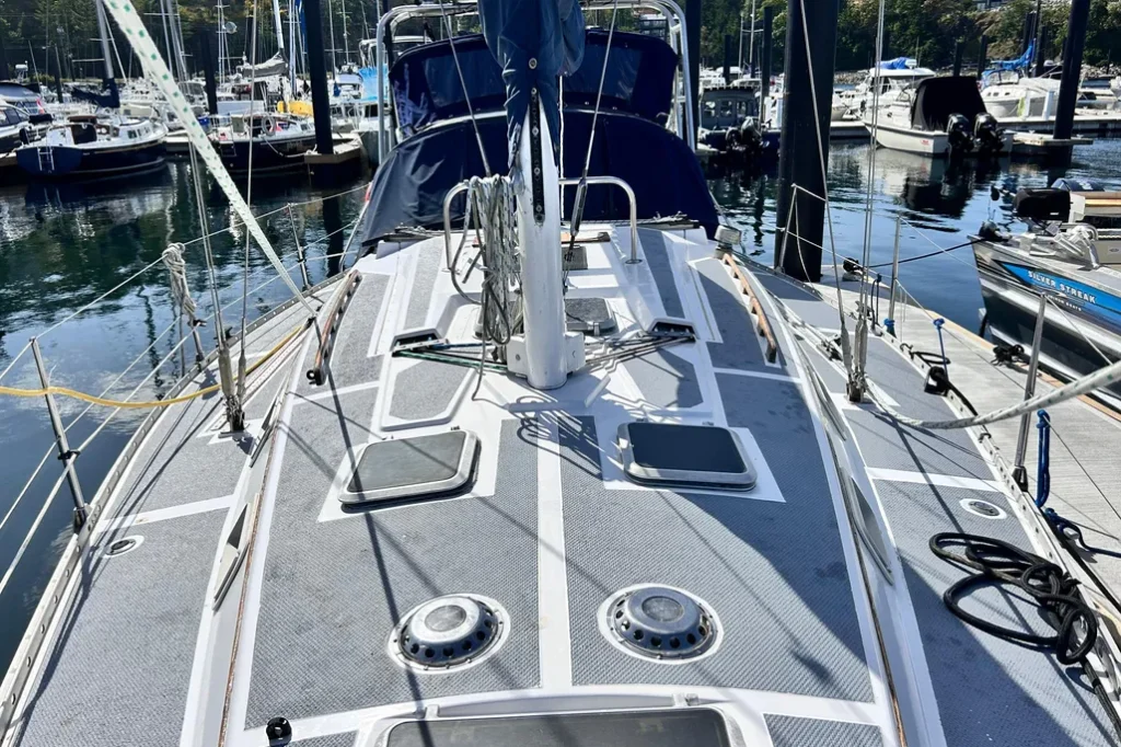 To combat the slippery molded non-skid, this owner applied an aftermarket solution. Wide side decks are a plus. Flush deck hatches bring air and light below, while the deck layout keeps lines easy to reach—a practical setup for daysailing and short-handed coastal cruising, though some owners report the molded deck components can be prone to cracking. Courtesy of Yacht World