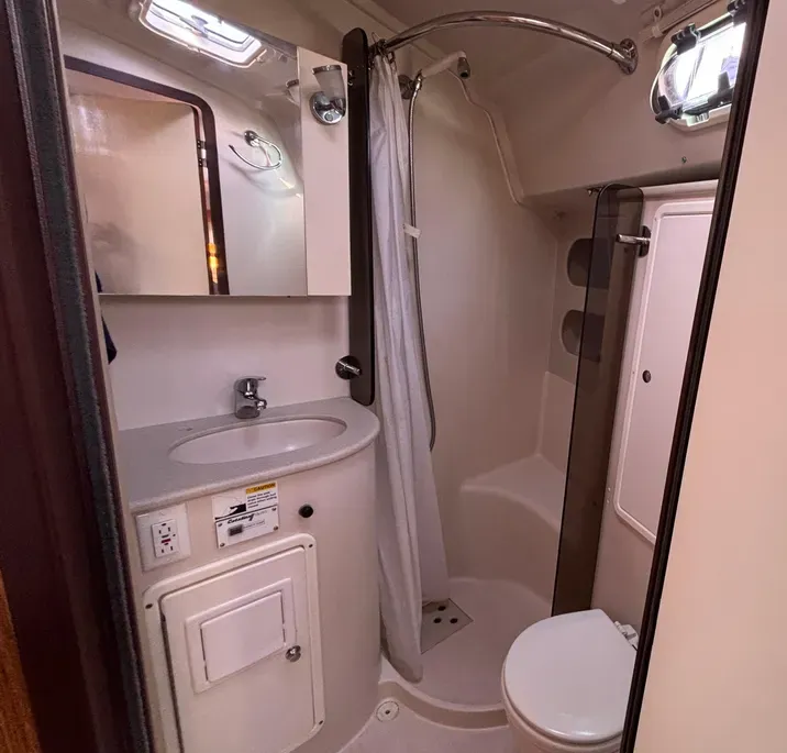 A separate shower stall adds rare comfort in a mid-size cruiser. Twin access doors—one from the saloon and one from the forward cabin—make the head unusually convenient for both day use and privacy. Courtesy of Yachtworld.com