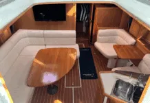 Warm varnished teak and solid wood doors create a space that feels substantial without being dark. The convertible furniture tries to solve the age-old problem of making one space do everything. Courtesy of Yachtworld.com