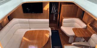 Warm varnished teak and solid wood doors create a space that feels substantial without being dark. The convertible furniture tries to solve the age-old problem of making one space do everything. Courtesy of Yachtworld.com