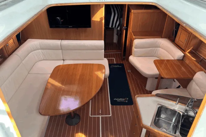 Catalina 375-Interior Warm varnished teak and solid wood doors create a space that feels substantial without being dark. The convertible furniture tries to solve the age-old problem of making one space do everything. Courtesy of Yachtworld.com