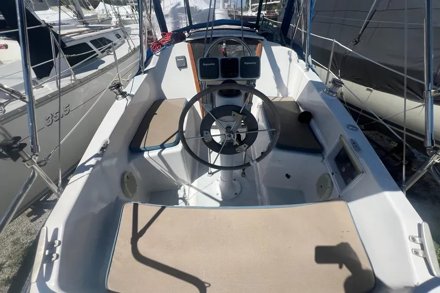 Wheel steering and high cockpit coamings offer comfort for five, though the layout leaves limited space for stowage; the starboard locker is dominated by the aluminum fuel tank. Courtesy of BoatTrader.com