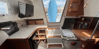 The Hunter 27 maximizes volume below with a just-over-six-foot headroom beneath the main hatch, teak trim, and a practical galley. Courtesy of BoatTrader.com