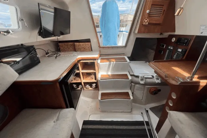 The Hunter 27 maximizes volume below with a just-over-six-foot headroom beneath the main hatch, teak trim, and a practical galley. Courtesy of BoatTrader.com