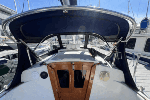 While not standard equipment, aftermarket bimini tops like this one address the Dana 24's high cabin profile, which provides excellent headroom below but offers little deck-level shade in tropical anchorages. Courtesy of Yachtworld.com