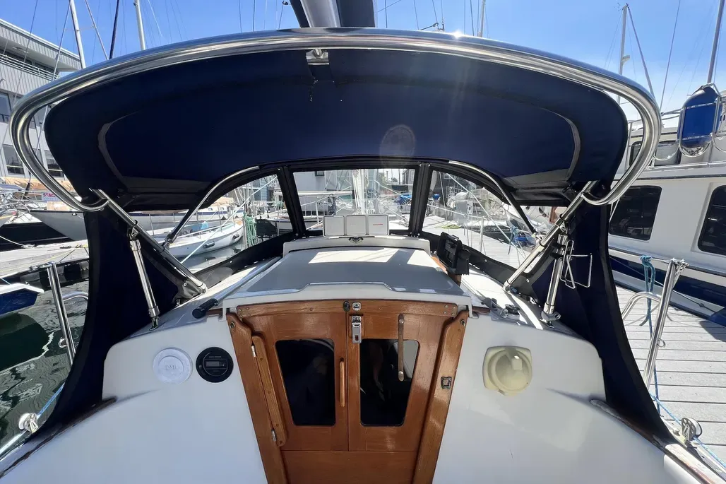 While not standard equipment, aftermarket bimini tops like this one address the Dana 24's high cabin profile, which provides excellent headroom below but offers little deck-level shade in tropical anchorages. Courtesy of Yachtworld.com